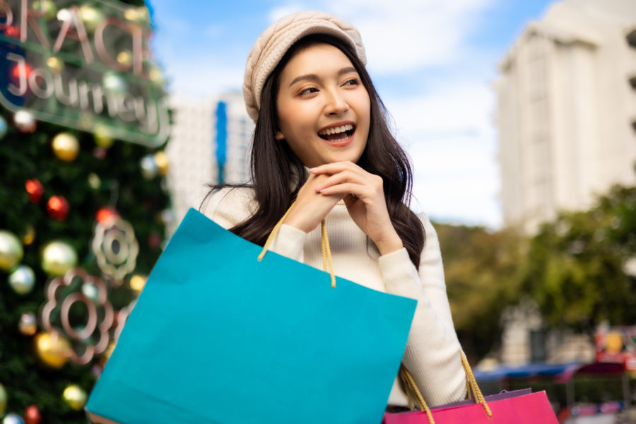Happy asian woman with shopping bags enjoying in shopping